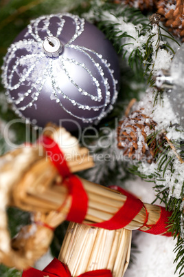 Silver Christmas bauble on a tree with snow