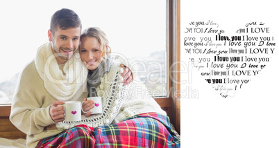 Composite image of loving couple in winter wear with cups agains