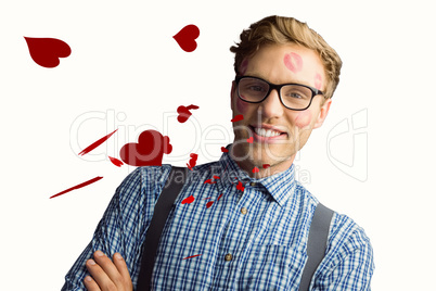 Composite image of geeky hipster covered in kisses