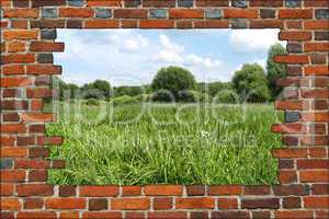 hole in the brick wall and view to summer field