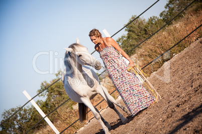 young woman walking a road with horse