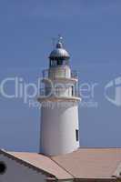 white lighthouse on rocks in the sea ocean water sky blue