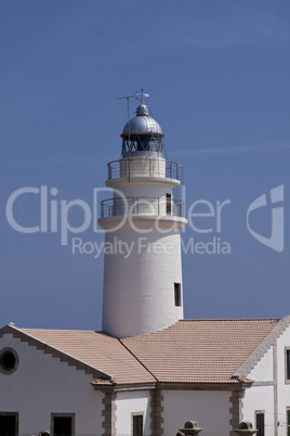 white lighthouse on rocks in the sea ocean water sky blue