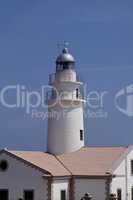 white lighthouse on rocks in the sea ocean water sky blue