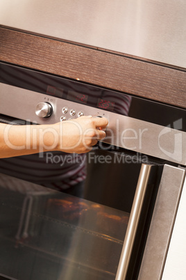 Close Up of Hand Turning Knob on Oven