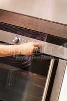 Close Up of Hand Turning Knob on Oven