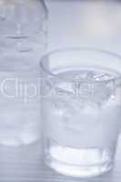 fresh cold clear mineral water in bottle and glass on table