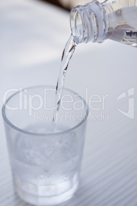 fresh cold clear mineral water in bottle and glass on table