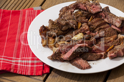 Plate of Grilled Steak and Garlic with Red Napkin