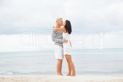 Couple holding hands while walking on the beach