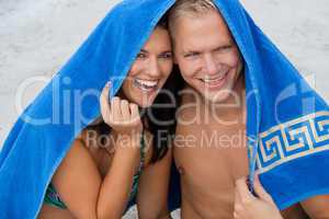Cheerful couple with a towel covering their heads