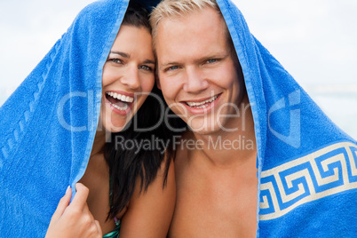 Cheerful couple with a towel covering their heads