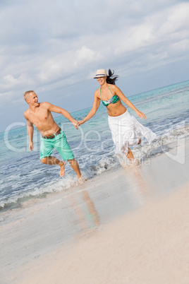 young happy couple walking on beach sunset holiday