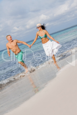 young happy couple walking on beach sunset holiday