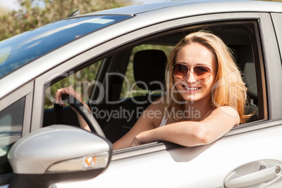 young attractive happy woman sitting in car summertime