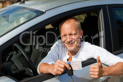 Excited driver holding the keys of his new car
