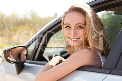 young attractive happy woman sitting in car summertime