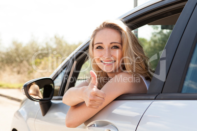 young attractive happy woman sitting in car summertime