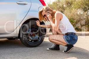 Woman inspecting her car engine after a breakdown