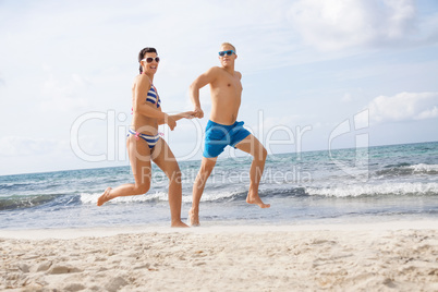 young happy couple walking on beach sunset holiday