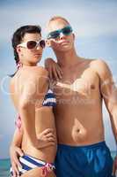 attractive young couple in swimwear and sunglasses