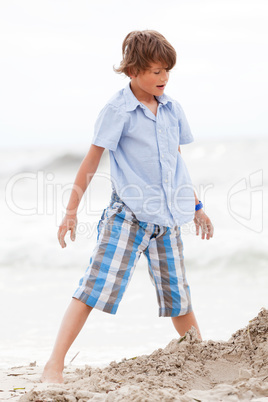 little boy playing in sand on the beach