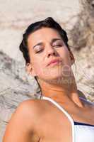 Beautiful woman sitting on golden beach sand
