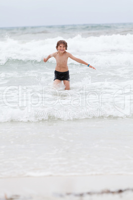young little boy in water summer holiday fun sea