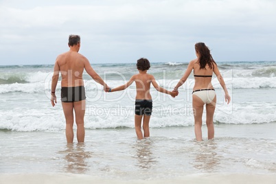 happy family ith two boys having fun in water summer holiday