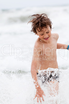 young little boy in water summer holiday fun sea