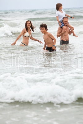 happy family ith two boys having fun in water summer holiday