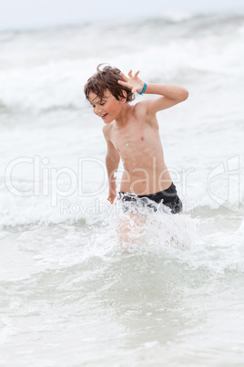 young little boy in water summer holiday fun sea