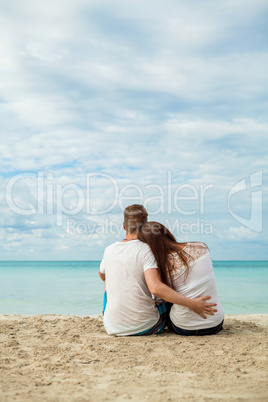 romantic young couple sitting on the beach in summer
