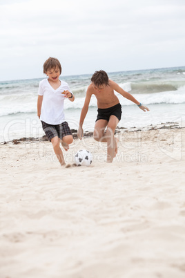 happy family father two kids playing football on beach summer