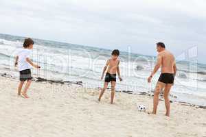happy family father two kids playing football on beach summer