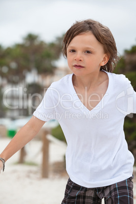 cute little boy playing in sand on beach in summer