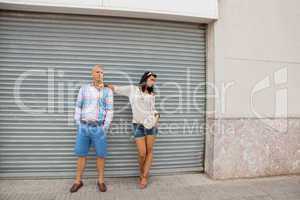 Fashionable couple posing in front of a metal door