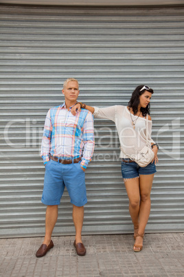Fashionable couple posing in front of a metal door