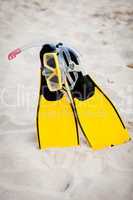 yellow fins and snorkelling mask on beach in summer