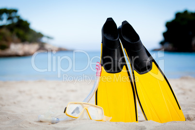 yellow fins and snorkelling mask on beach in summer
