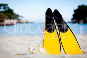 yellow fins and snorkelling mask on beach in summer