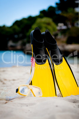 yellow fins and snorkelling mask on beach in summer