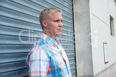 attractive young adult man with blue eyes standing outdoor