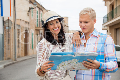 Young couple of tourists consulting a map