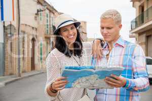 Young couple of tourists consulting a map