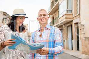 Young couple of tourists consulting a map