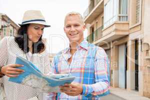 Young couple of tourists consulting a map