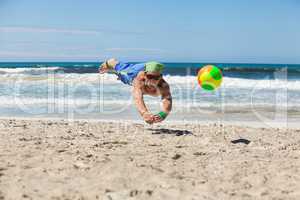 attractive adult man playing beach volleyball in summer