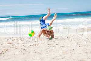 attractive young man playing volleyball on the beach