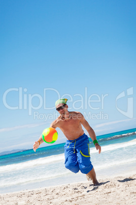 attractive young man playing volleyball on the beach